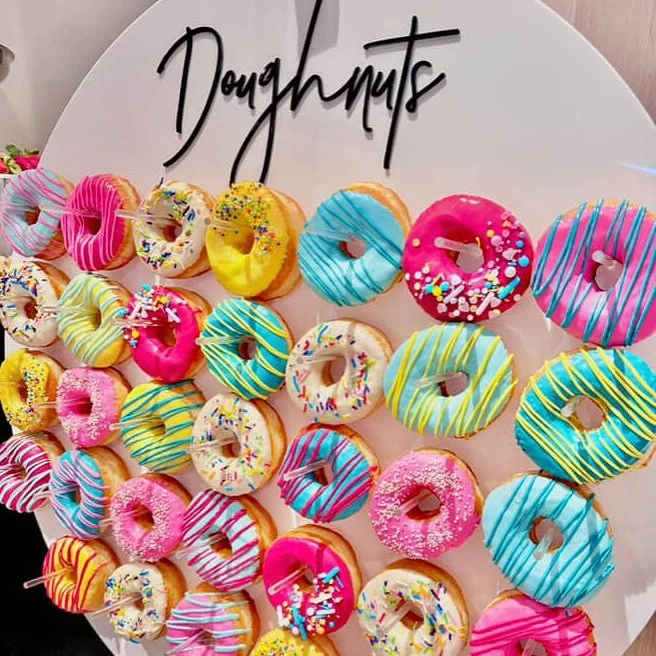 A vibrant mix of doughnuts displayed on our doughnut wall for a corporate event @crystalbrookvincent with our friends @prettybonitodesign