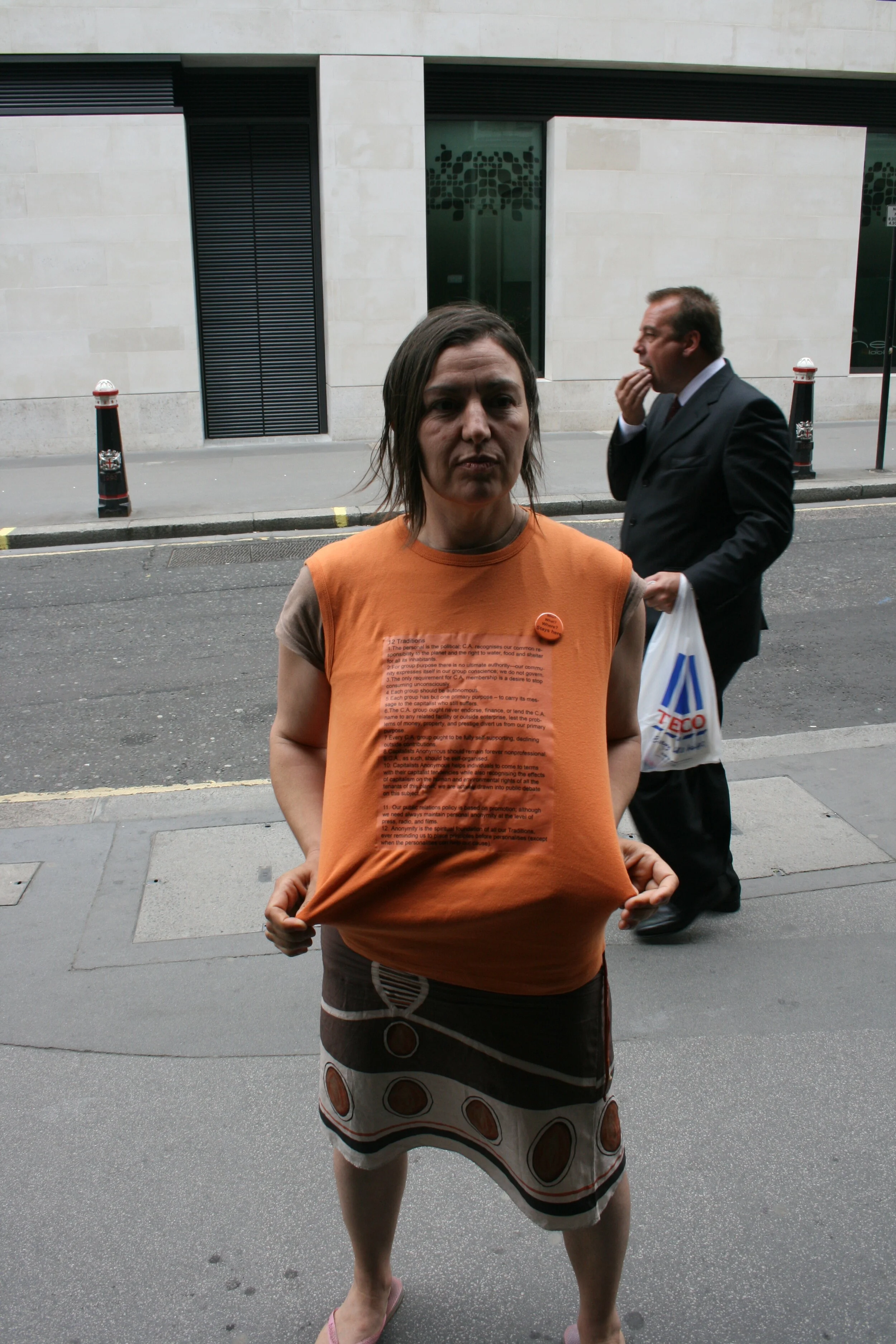 A young woman holds a t-shirt with a statement printed on it