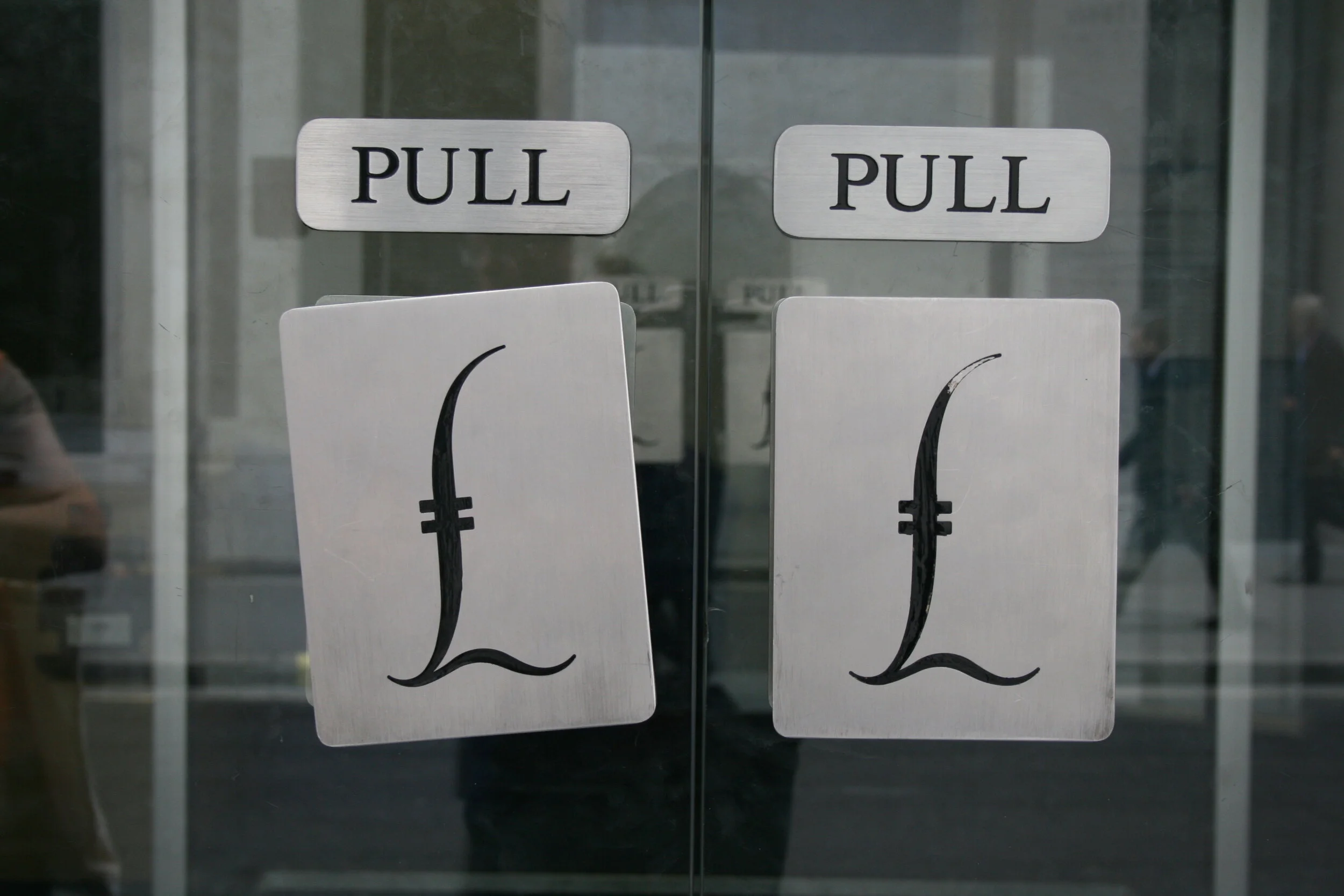 Glass doors each with the word Pull and below them a pound sterling sign