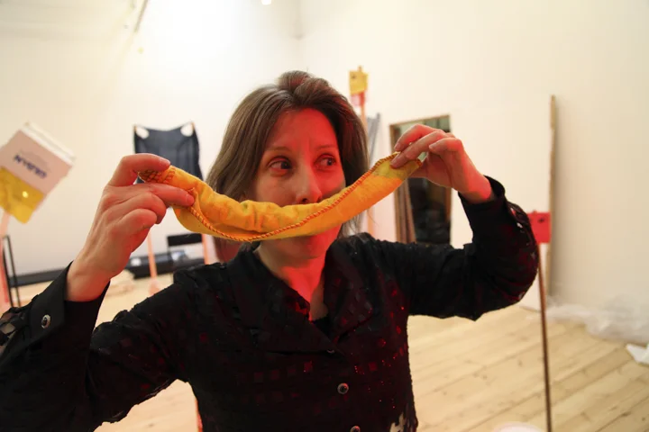 Hayley Newman holds up a rolled-up dishcloth that covers her mouth