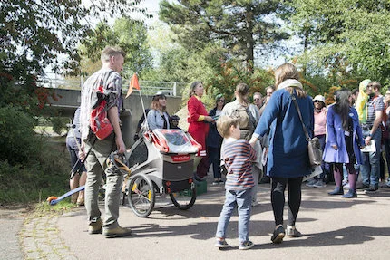 Group of people in the middle of which Hayley Newman stands in a red dress