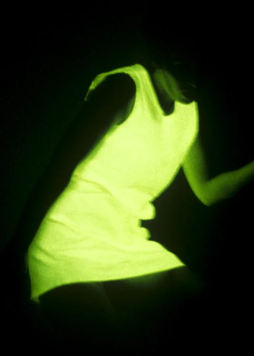 A sleeveless dress worn by Hayley Newman glowing green in darkness