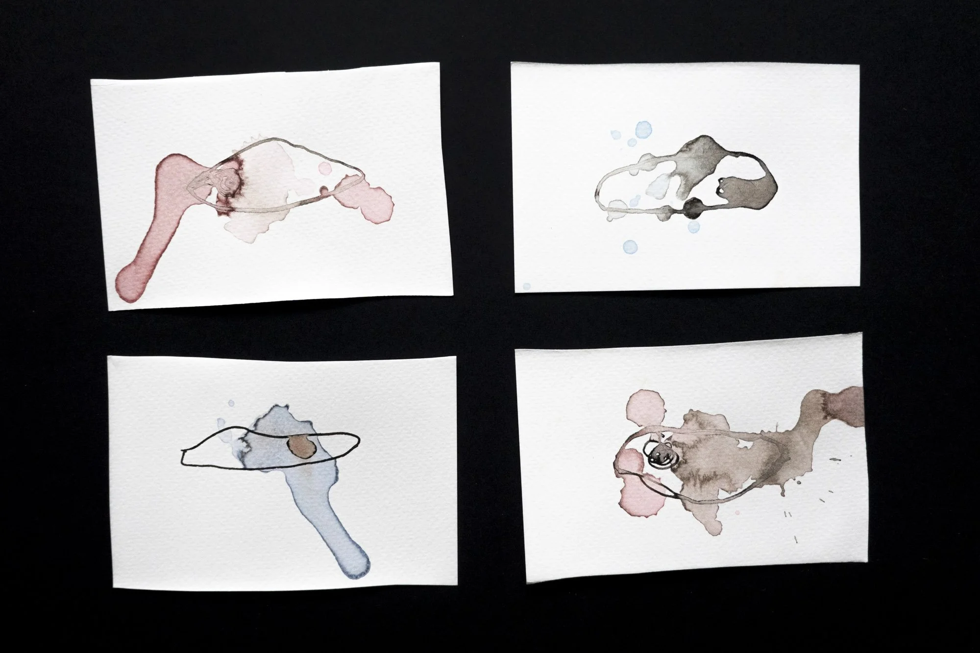 4 separate almost abstract ink drawings of single eyes in different colours