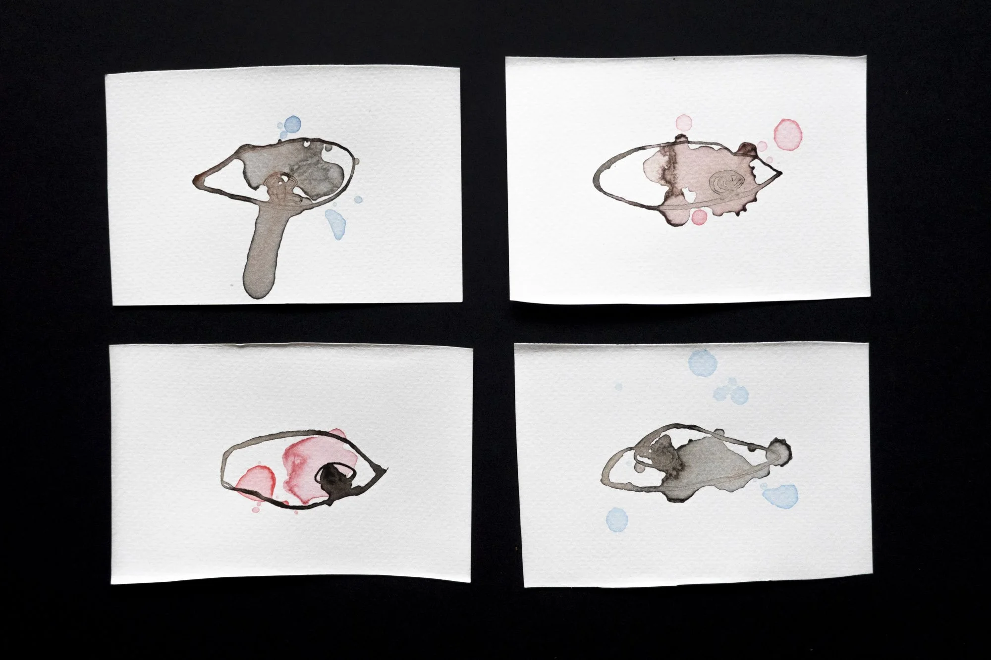 4 separate almost abstract ink drawings of single eyes in different colours