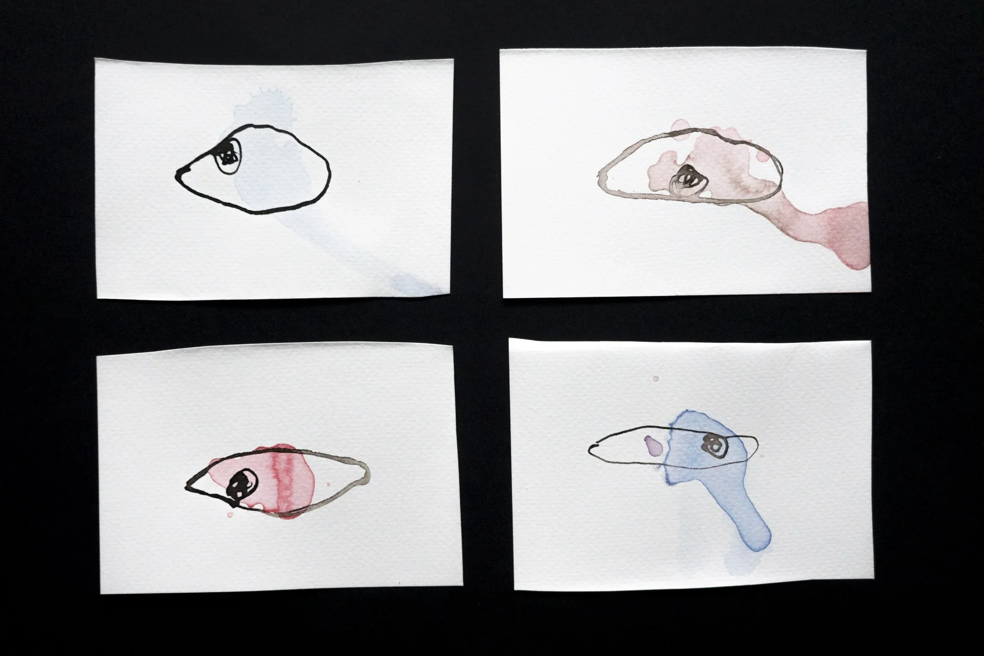 4 separate almost abstract ink drawings of single eyes in different colours