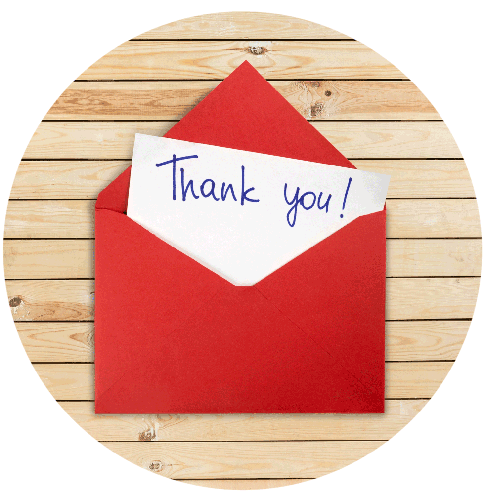 Thank you note in red envelope on wooden slats.