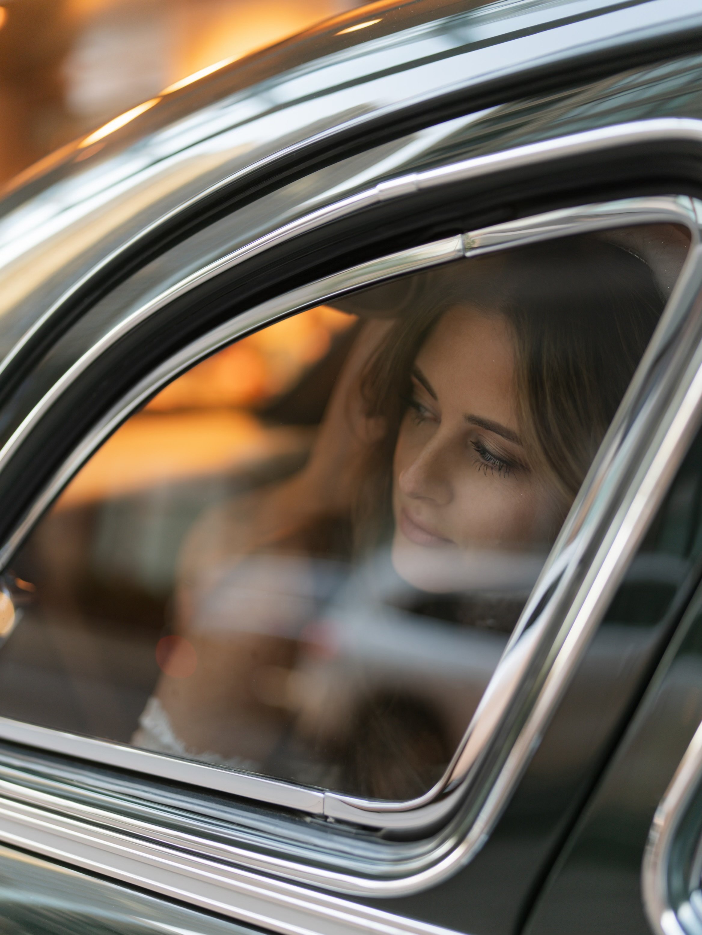Bride smiling through limo window on her Chicago wedding day
