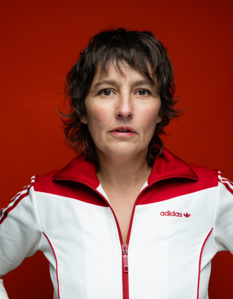 Photo of Viv Gordon looking at the camera against a red background