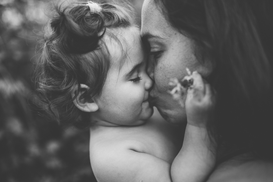 Liten dotter som pussar mamma