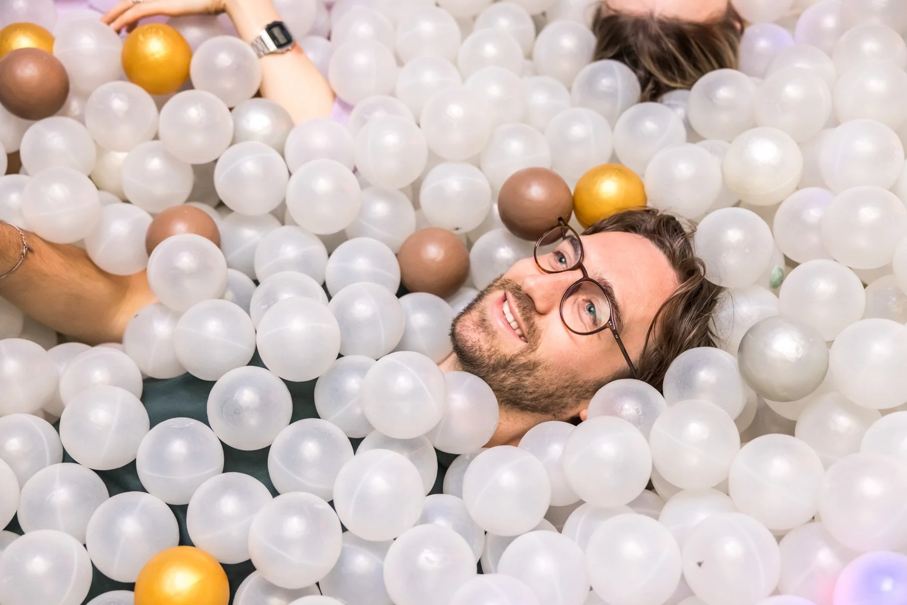 Experiential brand photography of man in ball pit