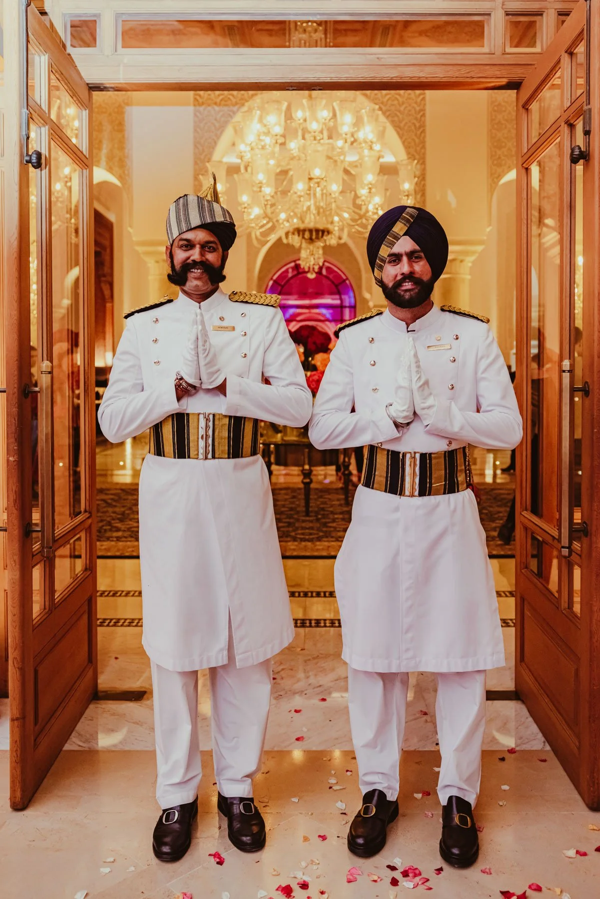 Men in formal attire greeting guests on arrival