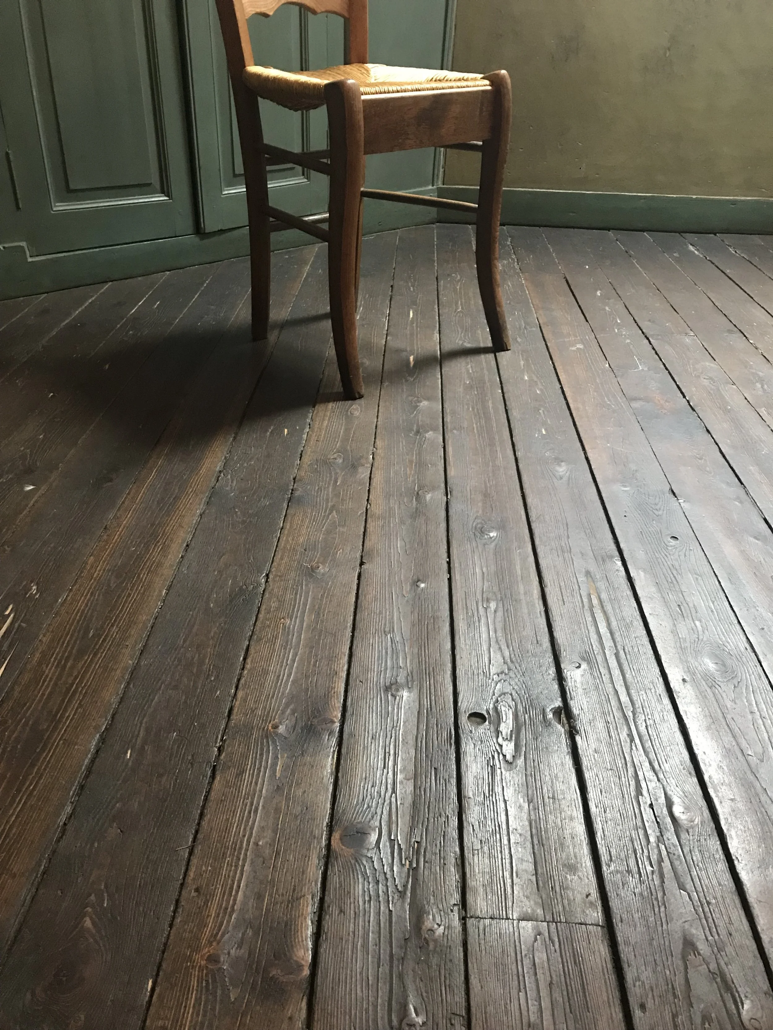 Sunlight warming the wooden floorboards in Van Gogh's room at the Auberge Ravoux