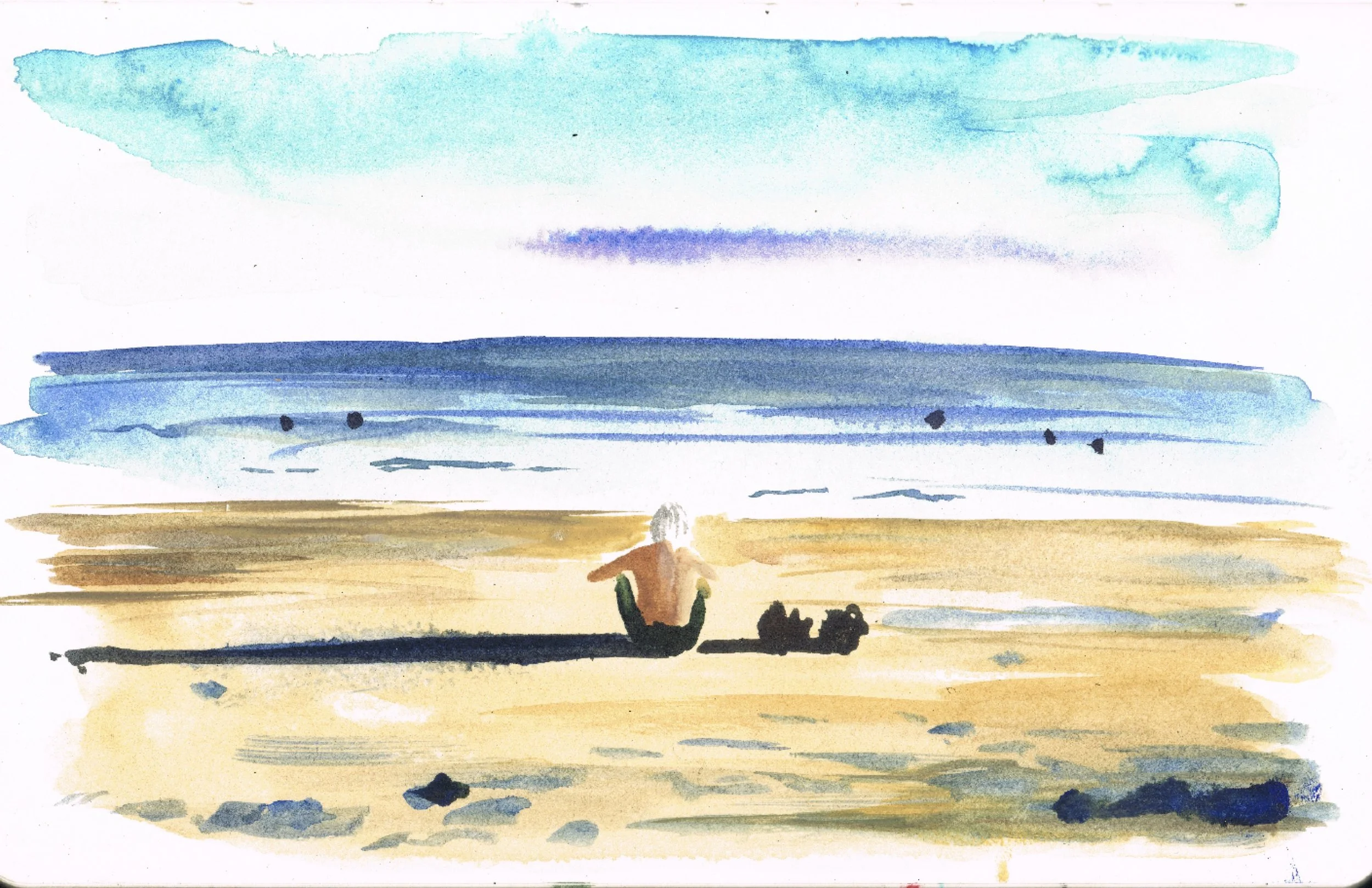 Man sat on Yuigahama beach looking out to sea