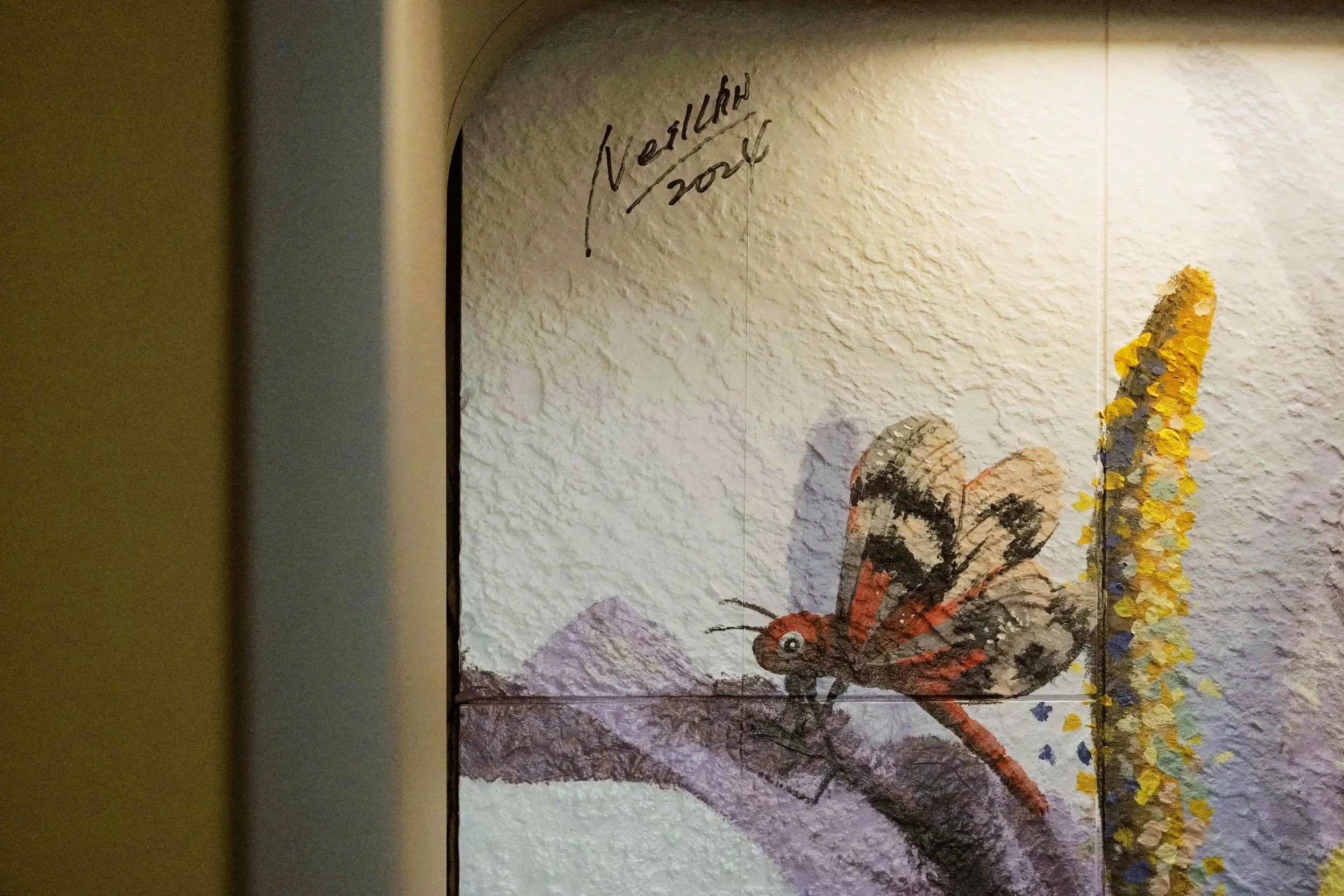 A mural created and painted by artist Neil Wang features a close-up of a red dragonfly resting on a purple petal, in Novoland Hong Kong by Sun Hung Kai Properties.