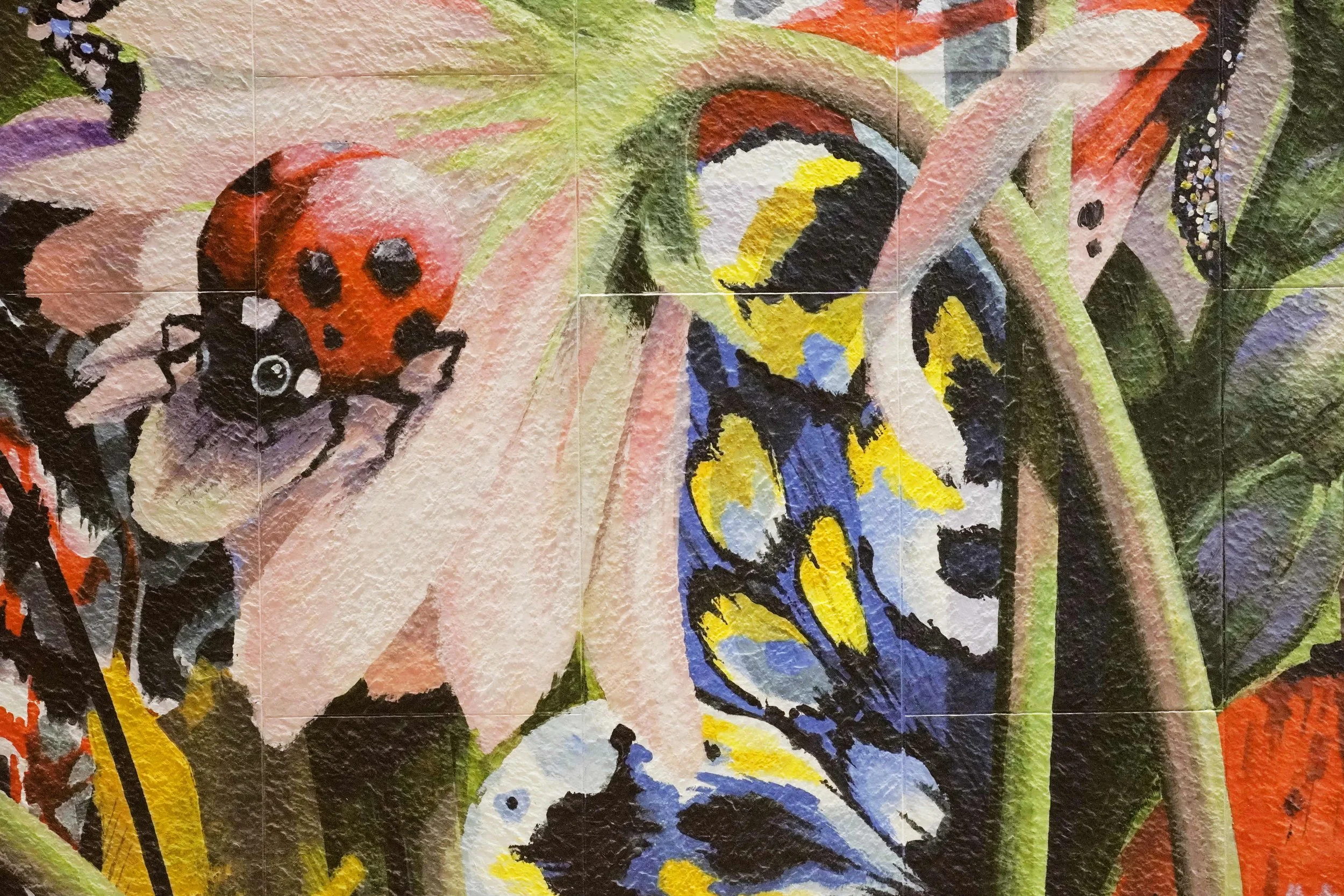Details of a residential estate mural created and painted by artist Neil Wang, a close-up capturing ladybirds, butterflies, and floral details, in Novoland Hong Kong by Sun Hung Kai Properties.