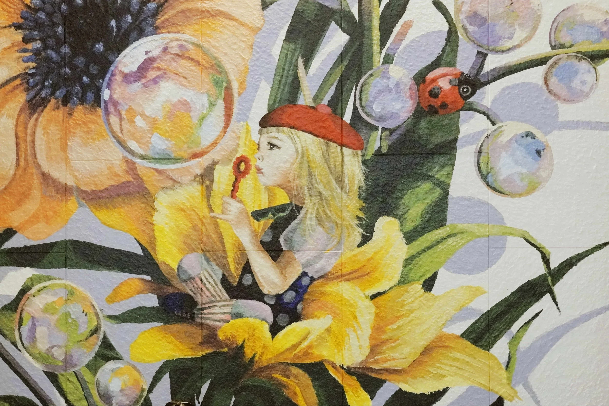 A mural created and painted by artist Neil Wang features a girl in a colorful outfit, sitting on a flower and blowing bubbles, in Novoland Hong Kong by Sun Hung Kai Properties.