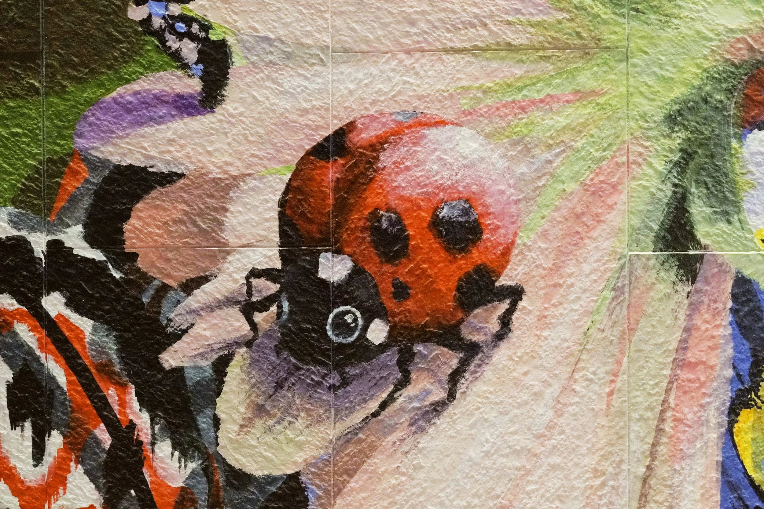 Details of a nature mural created and painted by artist Neil Wang, a close-up capturing a ladybird on a flower, wall painting in Novoland Hong Kong by Sun Hung Kai Properties.