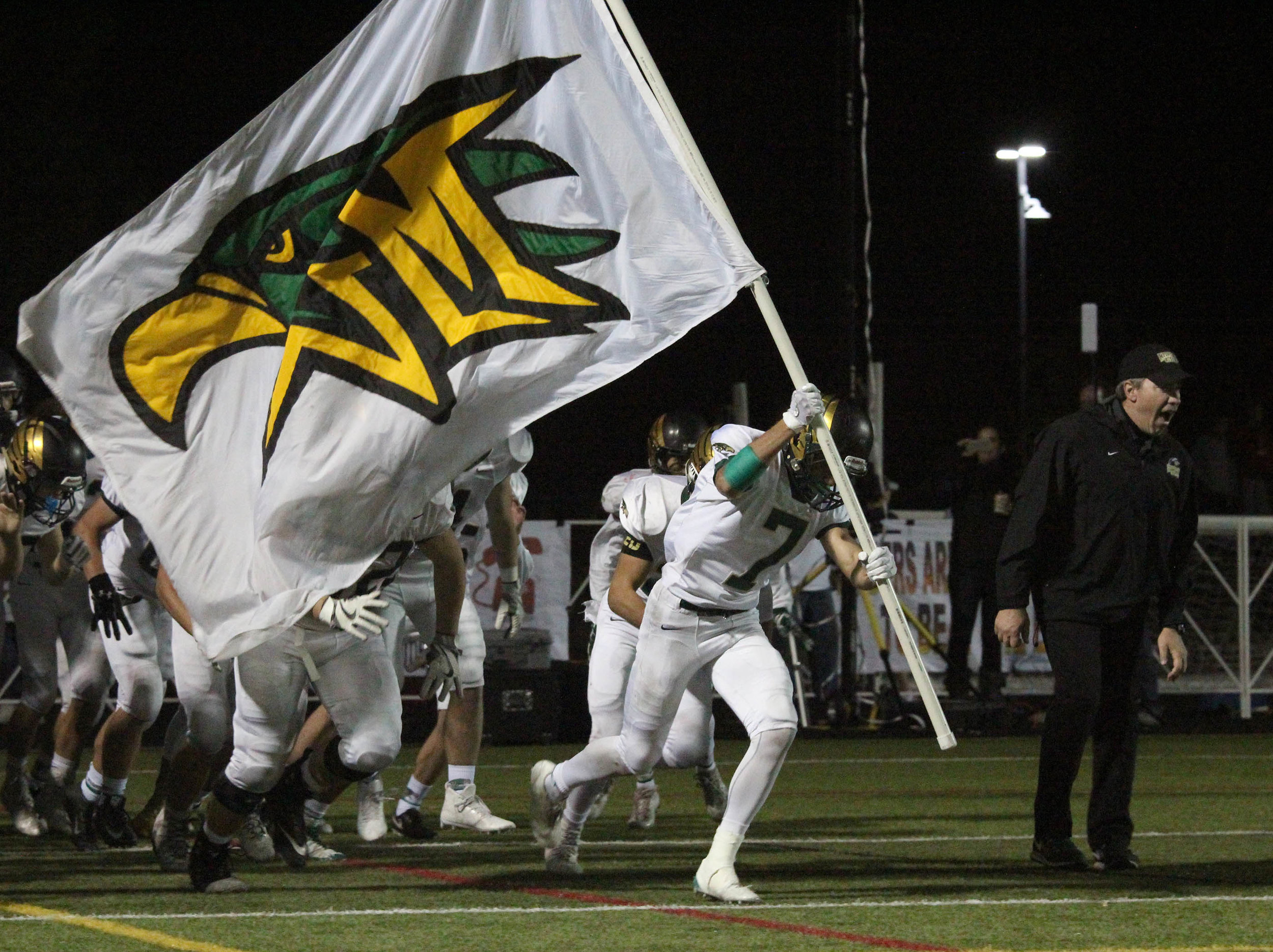 Senior Tristan Smith leads the team onto the field against Regis High School. 