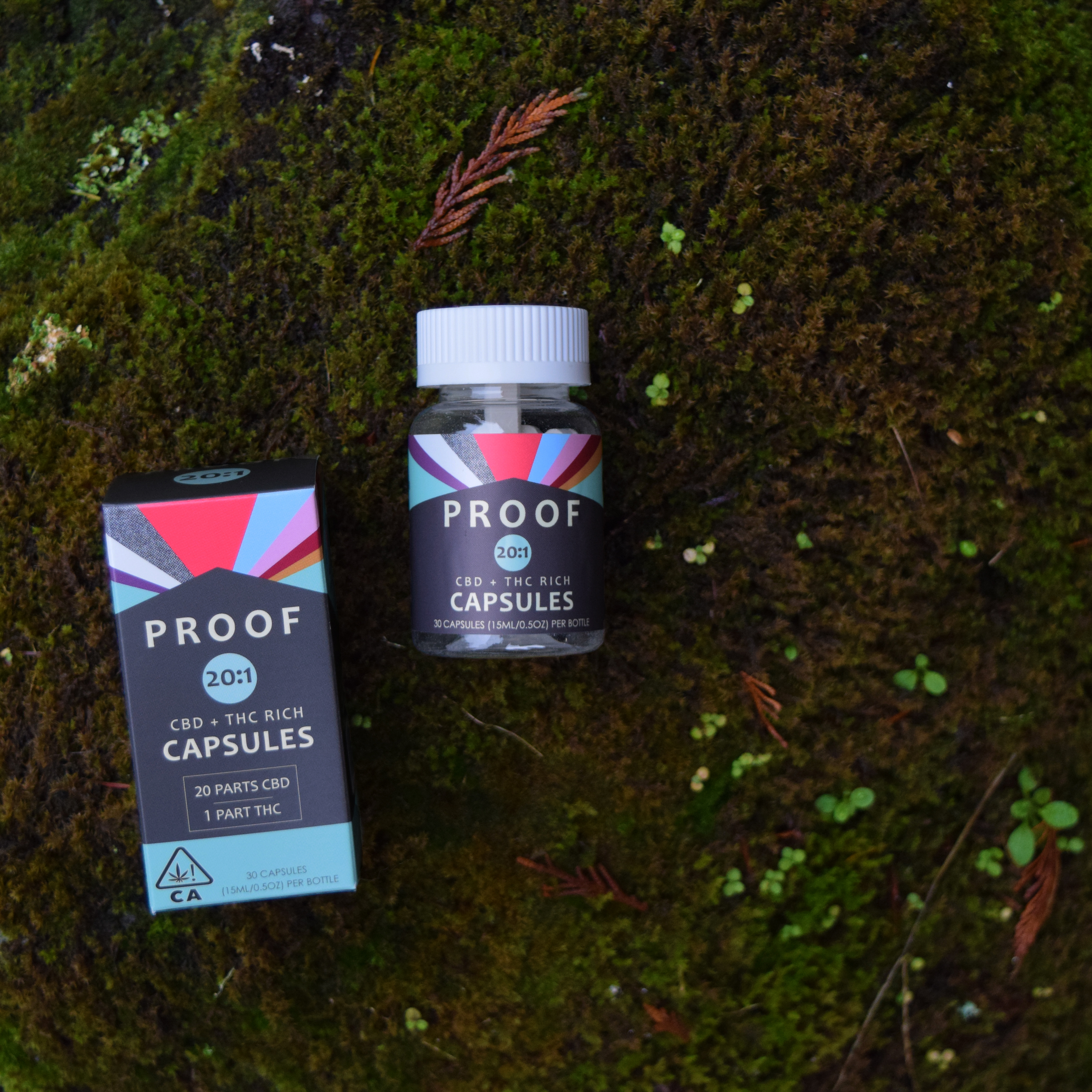 Bottle and box of Proof High CBD Capsules on a moss-filled forest floor.