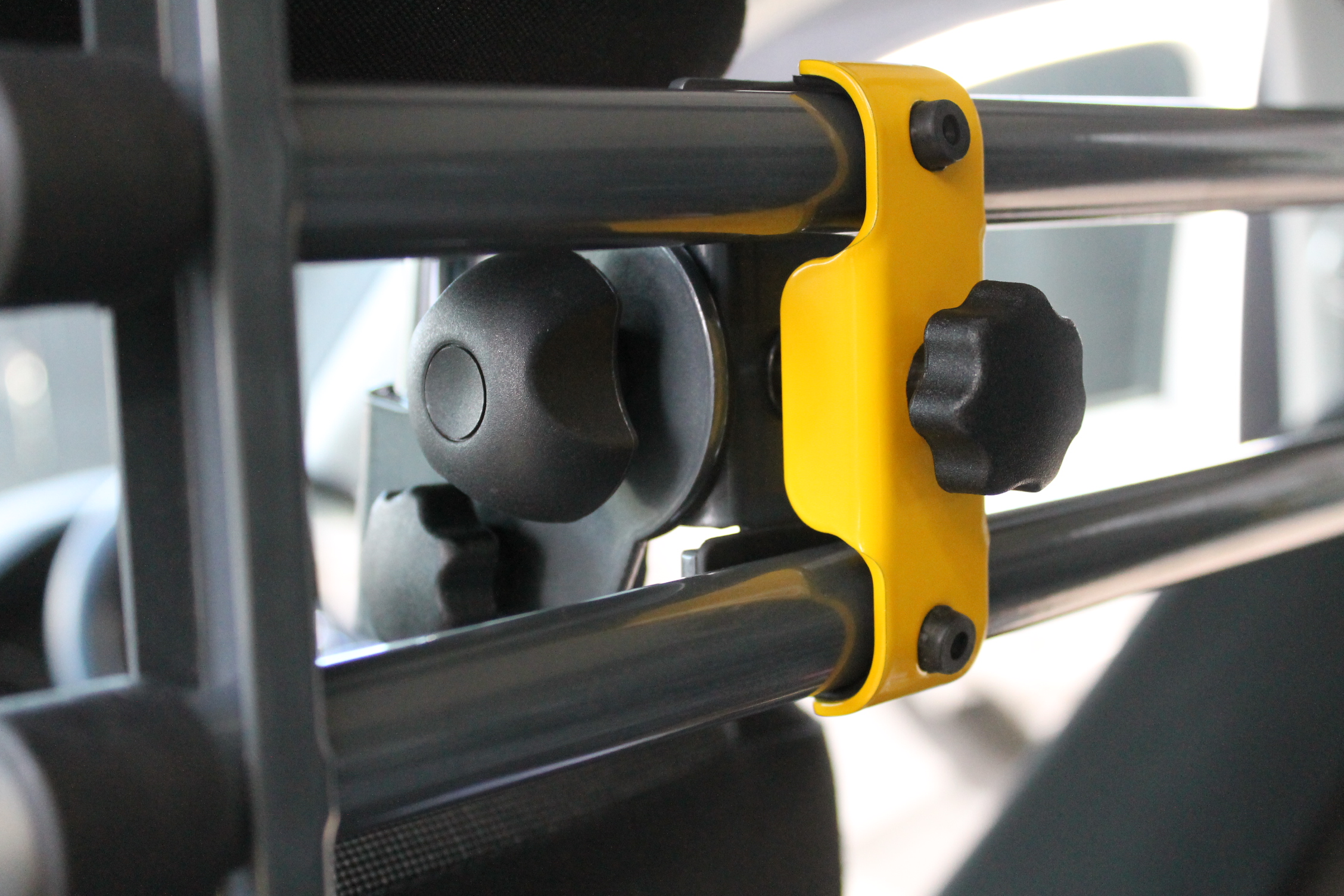 Yellow clamp attaches the bars to the attachment mechanism.