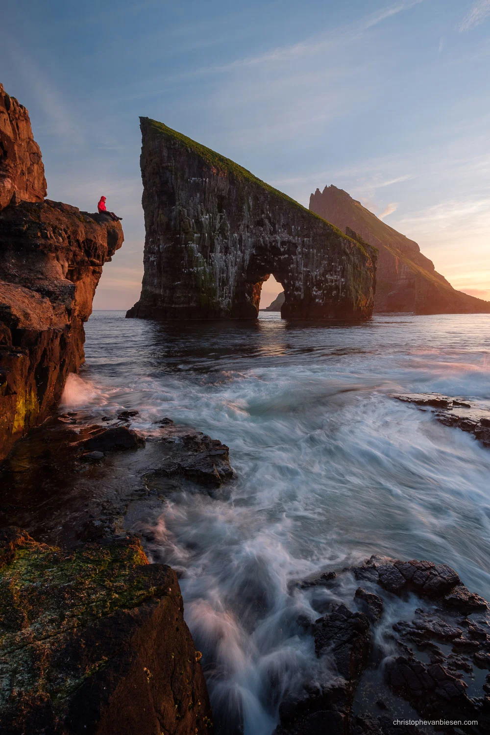 Faroe Islands - Vagar - Traveller contemplating the dramatic sea stacks of Drangarnir and Tindhólmur from the islands of Vagar in the Faroe Islands