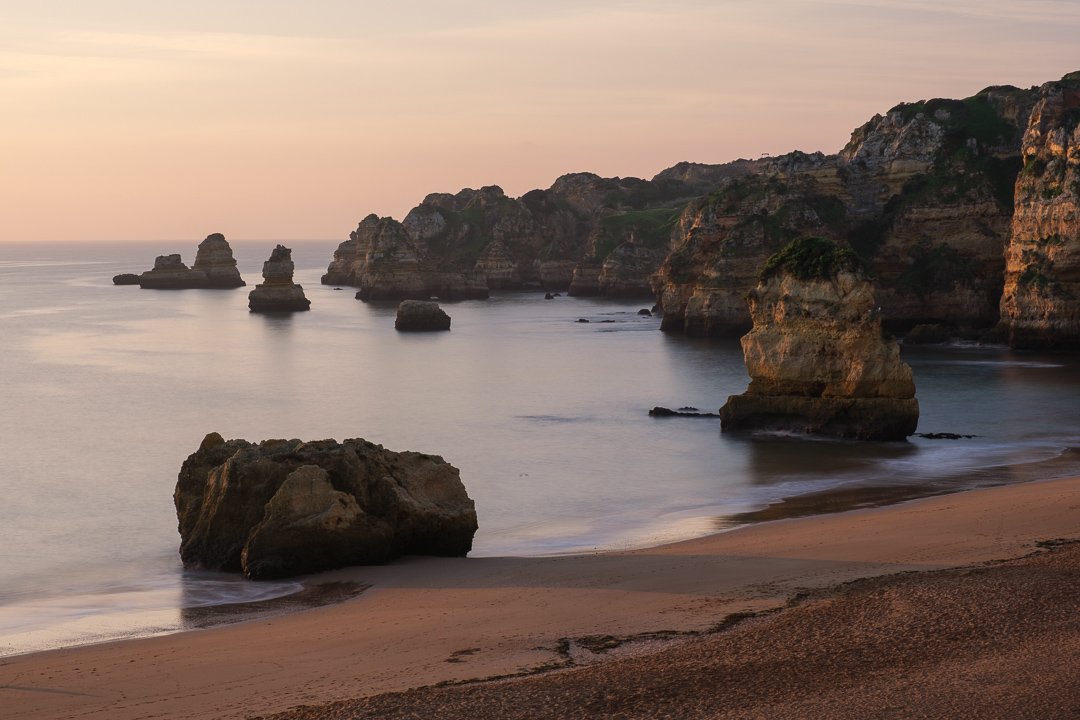 Sunrise in the Algarve is a breathtaking experience. The sun rises over the Atlantic, painting the sky with hues of pink, orange, and gold. The tranquil beaches and rugged cliffs are bathed in soft light, creating a serene and magical atmosphere that