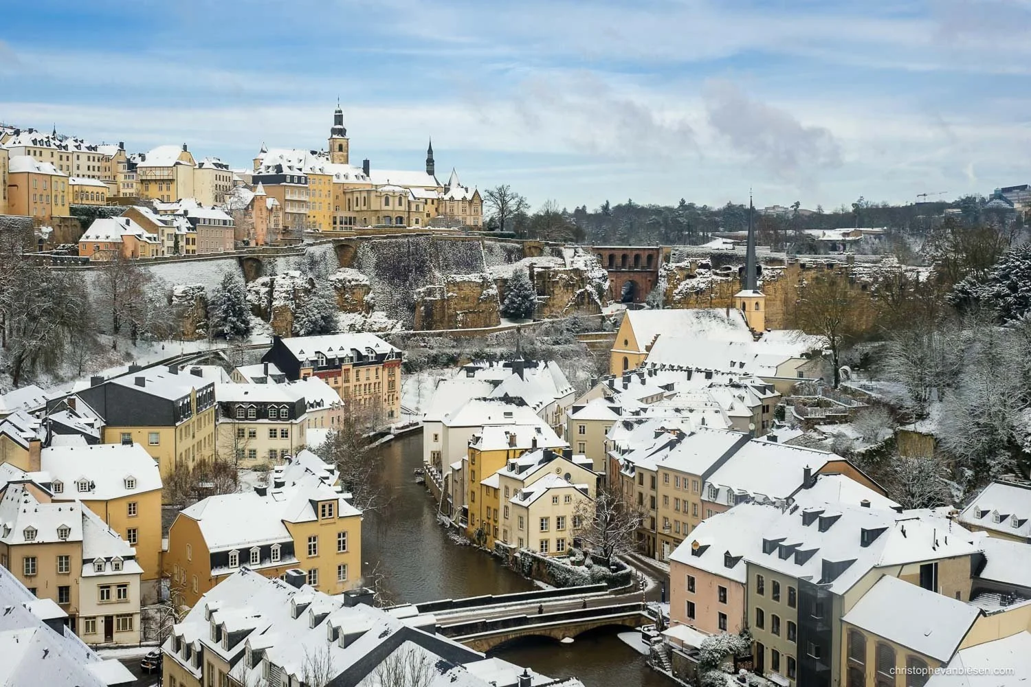 Snow-covered rooftops in the Grund, Luxembourg City, beside the Alzette and beneath the old town.