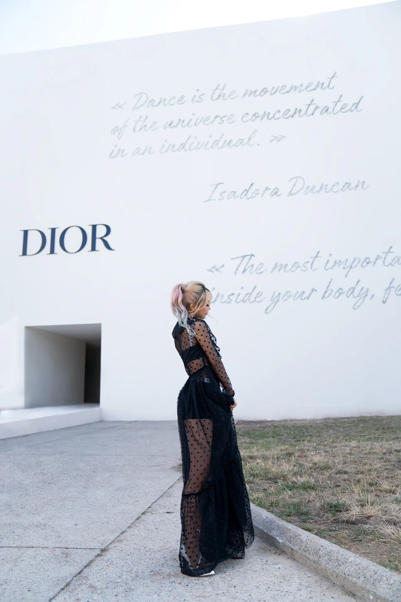 Wengie poses in front of the grand entrance to the Dior show