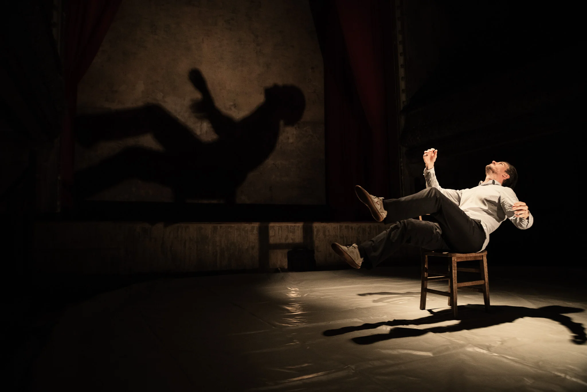 Ben Duke in one of the scenario lit with different lights angled to accentuate the presence of his own shadow.