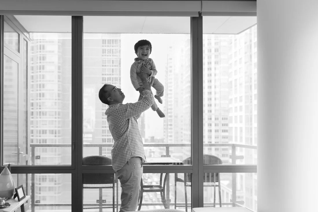 Dad playing helicopter with son during a New York Family photography session at home