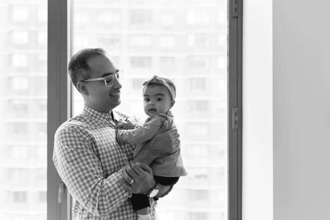 Dad holding his daughter and looking at her tenderly during a family photography session