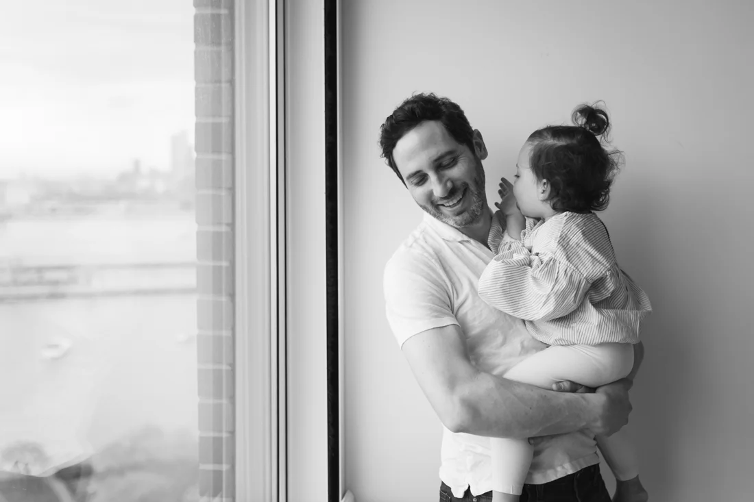 Father and daughter hugging and laughing during in home session