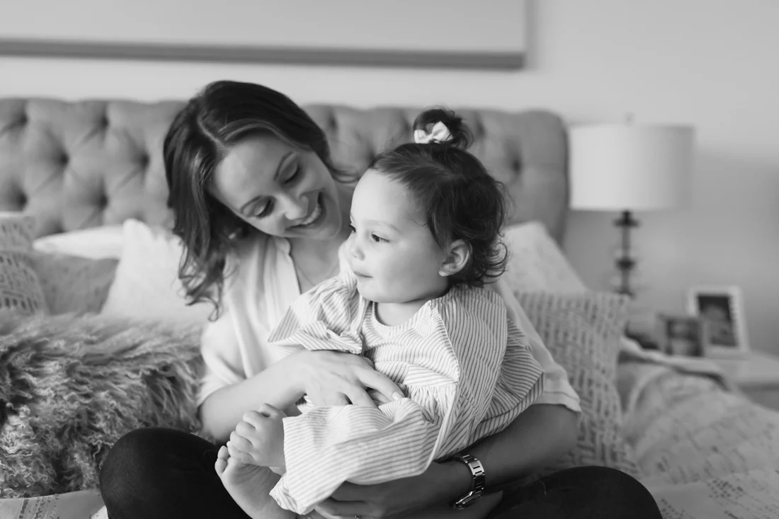 Mother looking at daughter holding her foot