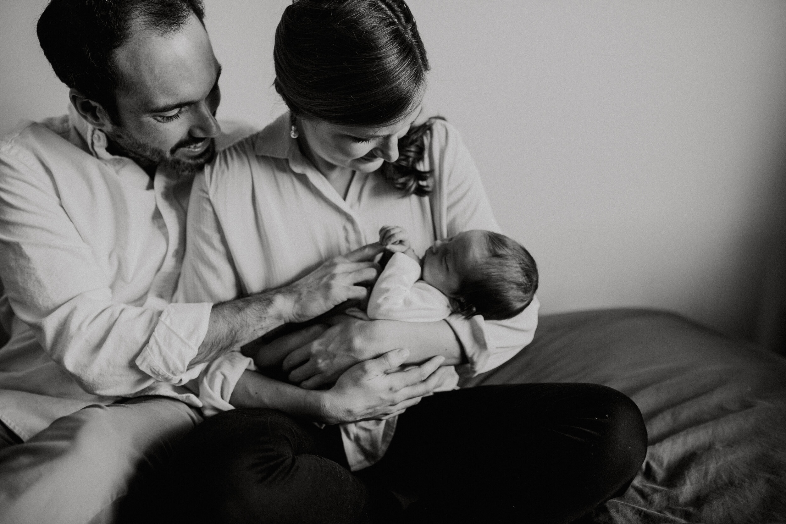 First time parents holding their baby girl during an in home session with Paris Newborn Photographer Helene Djebiri
