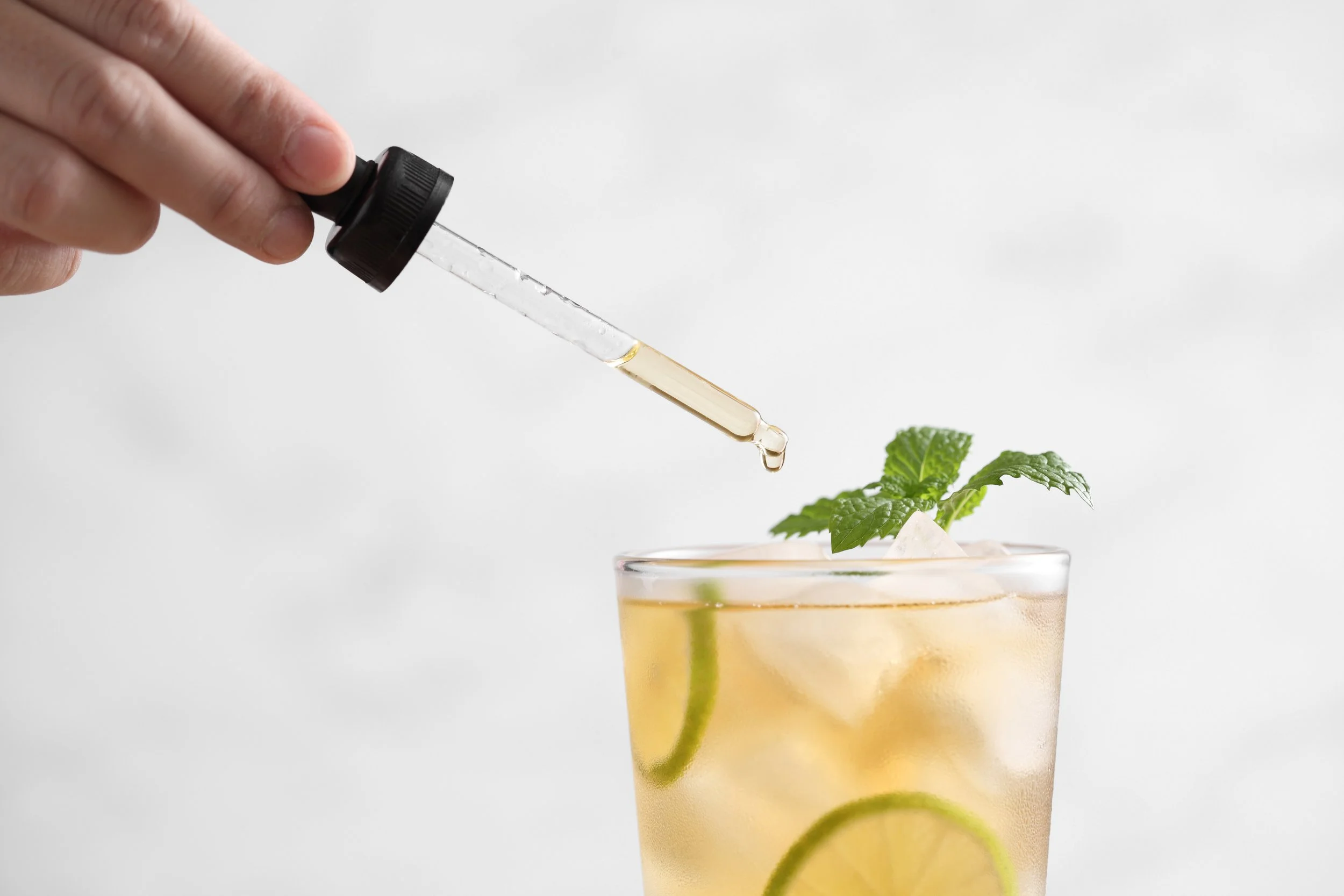 Adding a dash of bitters to a cocktail or mocktail
