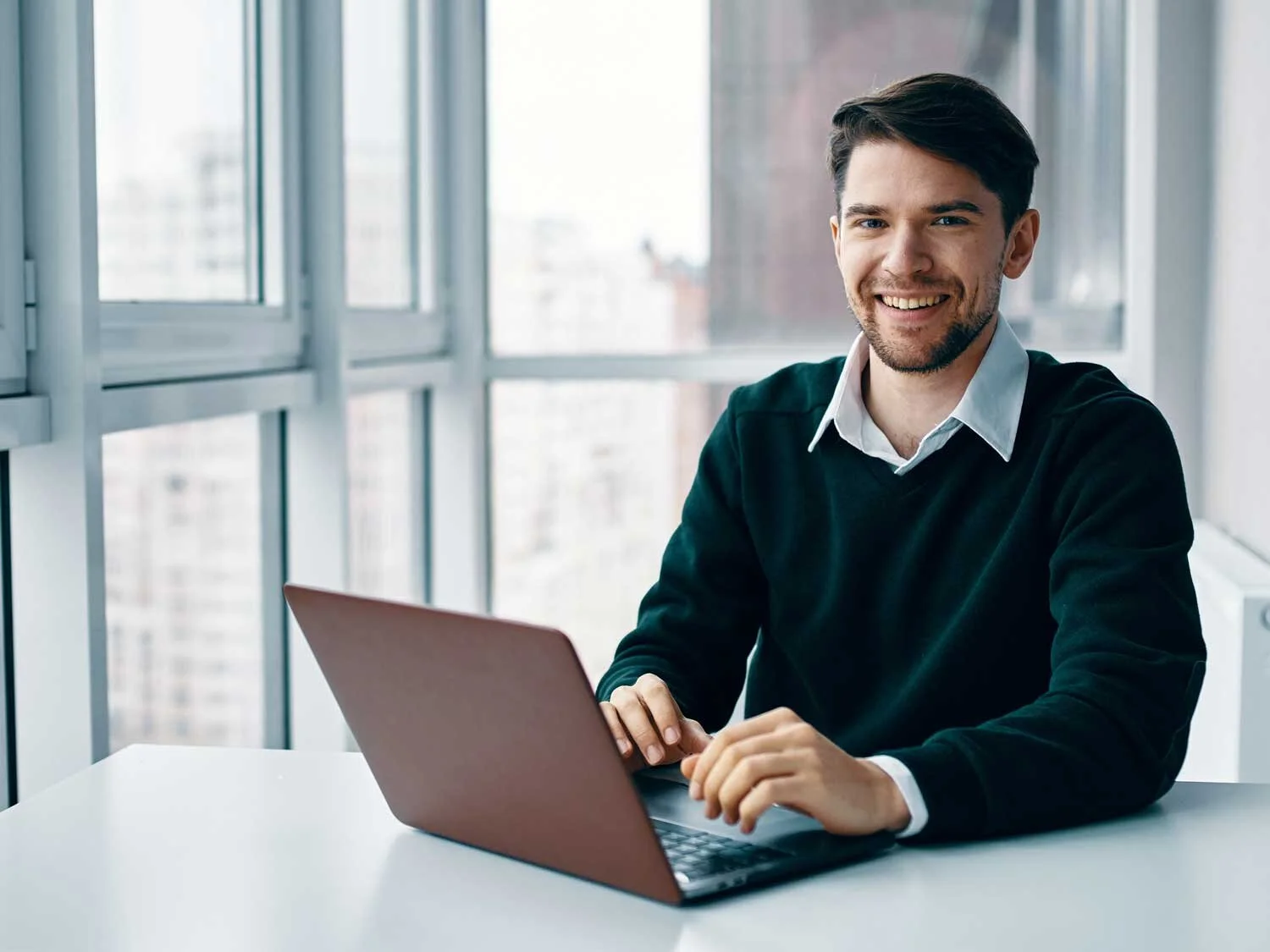 young-man-with-laptop-business-suit-working-office-home-background-window-interviewing-online.jpg
