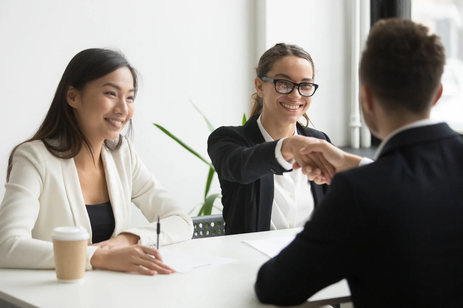businessman-shaking-hand-female-coworker-during-company-meeting.jpg