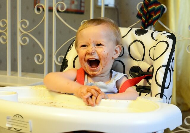 child in highchair with messy face.jpg