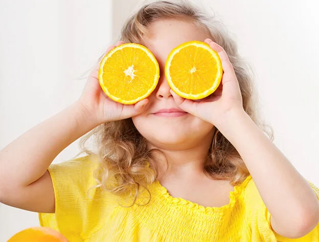 Girl with oranges over her eyes.jpg