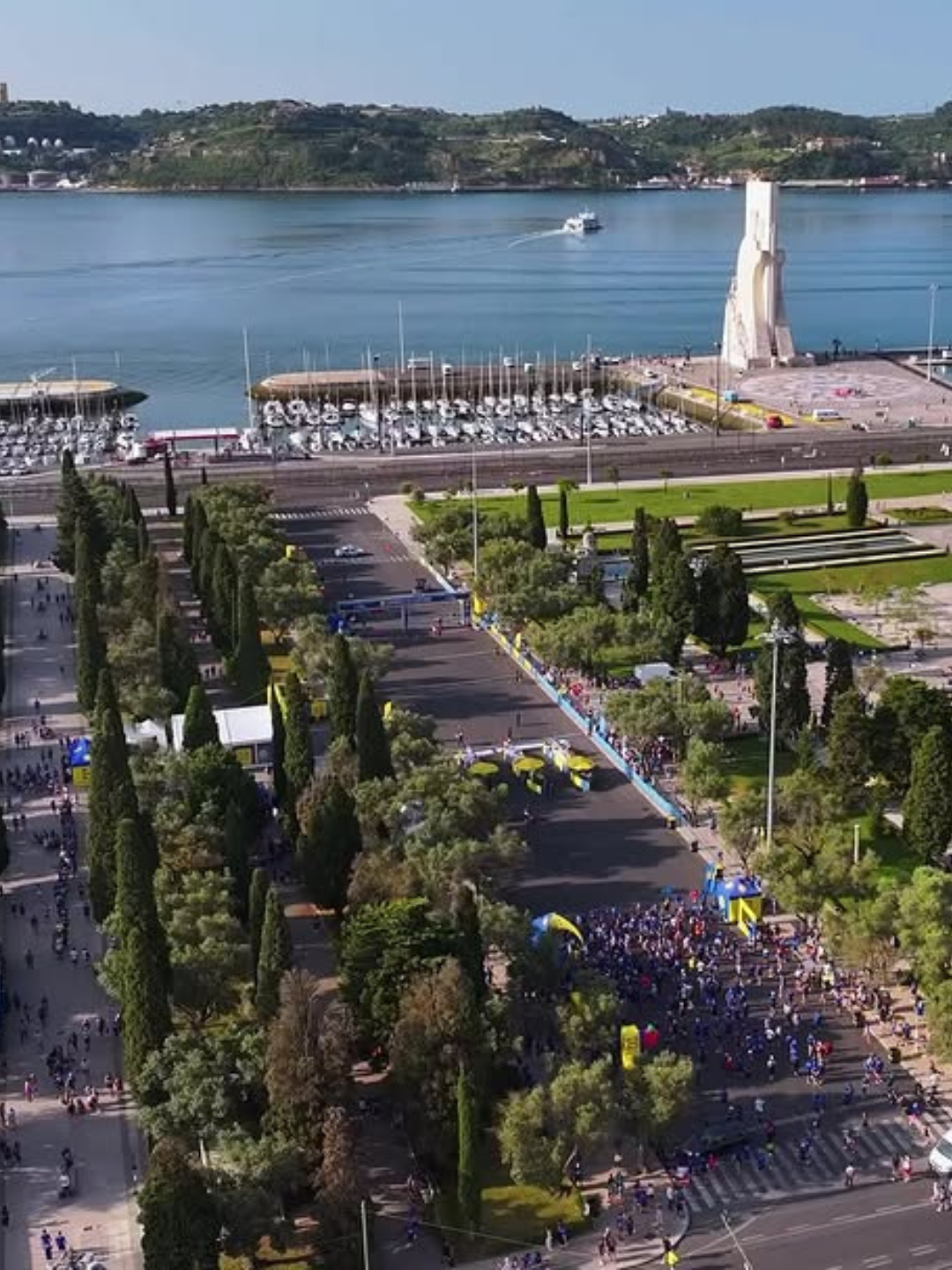 Runners crossing the finish line at the Corrida de Santo António along the Tagus in Belém, Lisbon, with every finisher receiving a traditional manjerico basil pot on 7 June 2026.