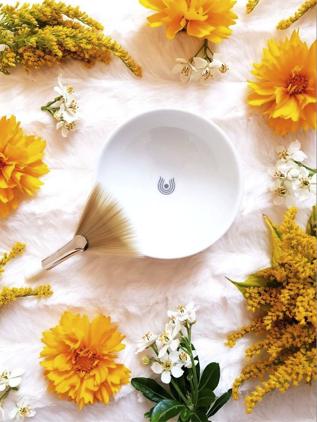 dr-hauschka-facial-treatment-bowl-brush-calendula-flowers-flat-lay