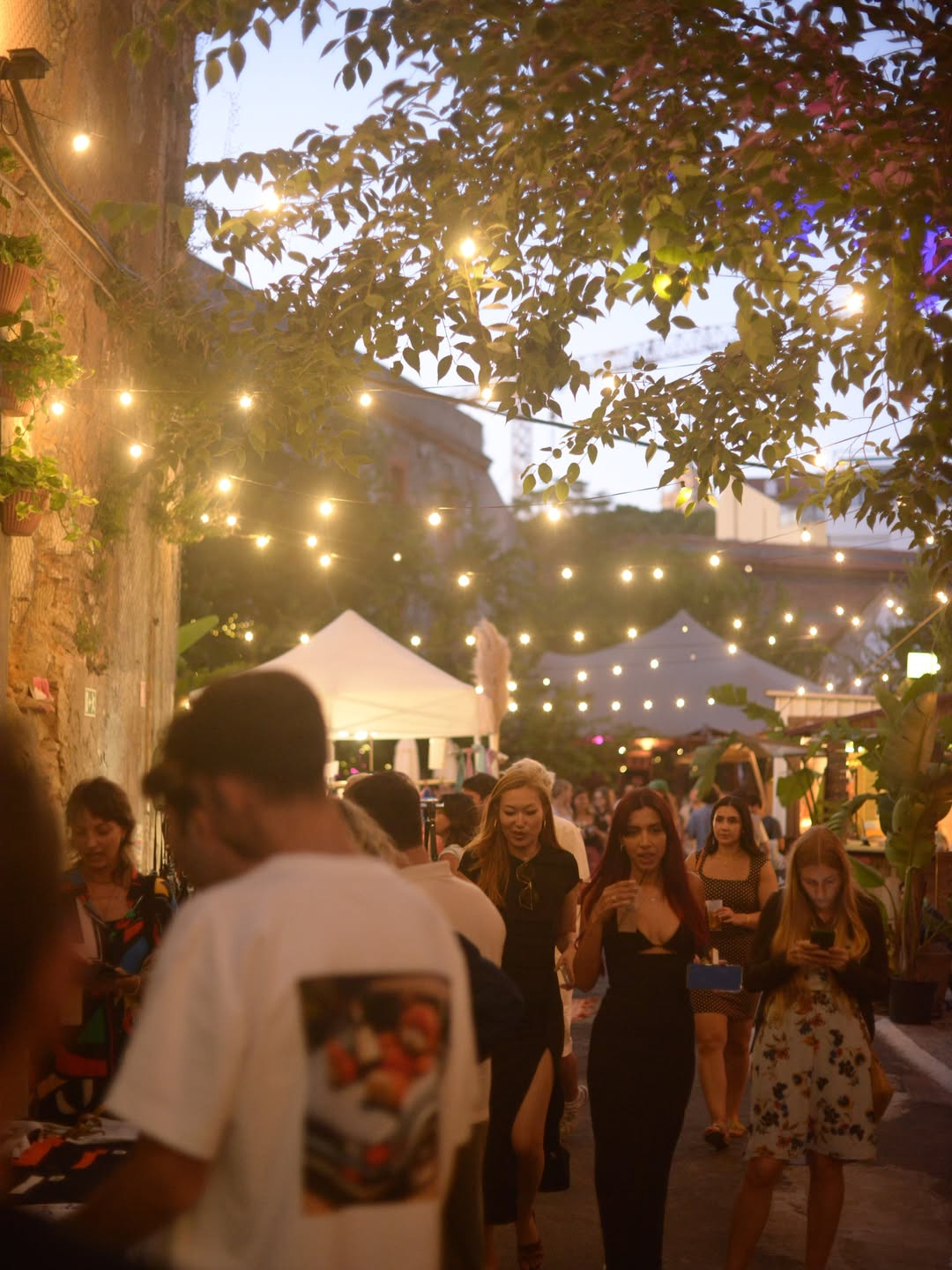 Visitors browsing independent brand stalls and food trucks at Amazonas Market at Campo das Cebolas by the Tagus river in Lisbon, across two free-entry weekends in June.