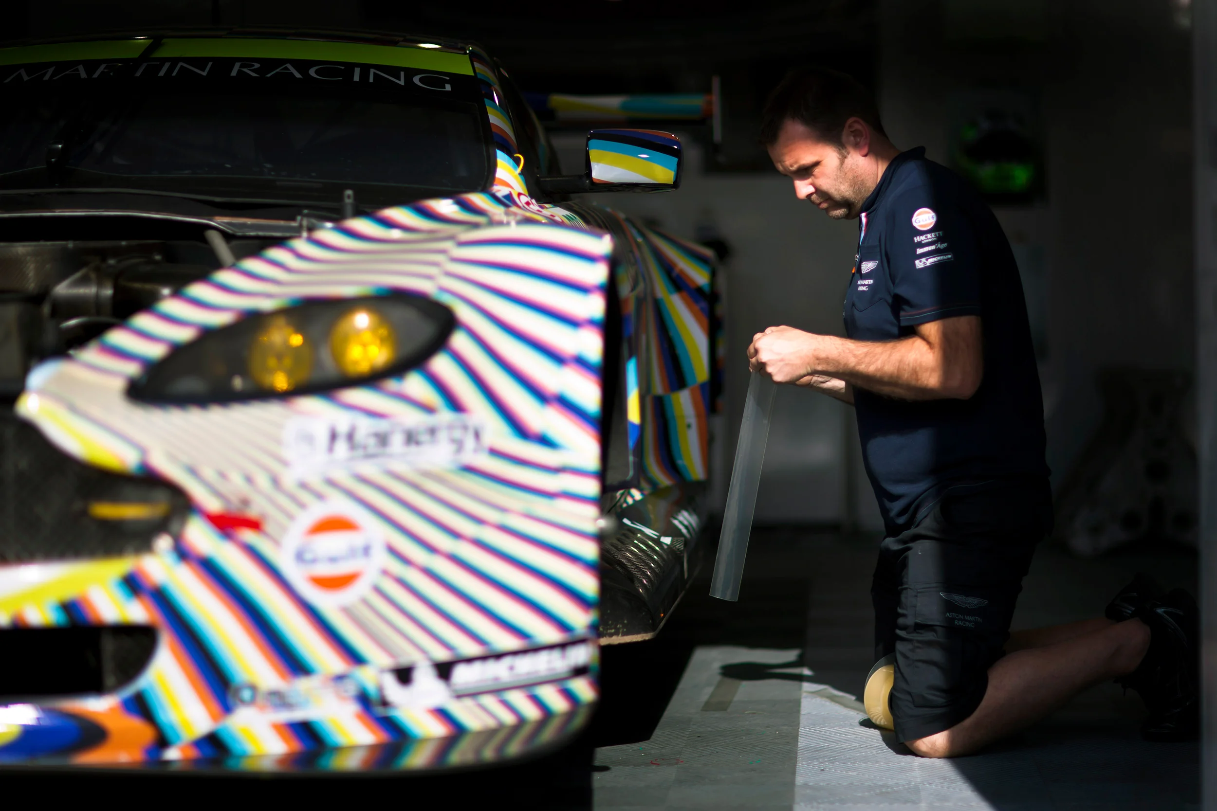 A team member works on the #97 Aston Martin Vantage