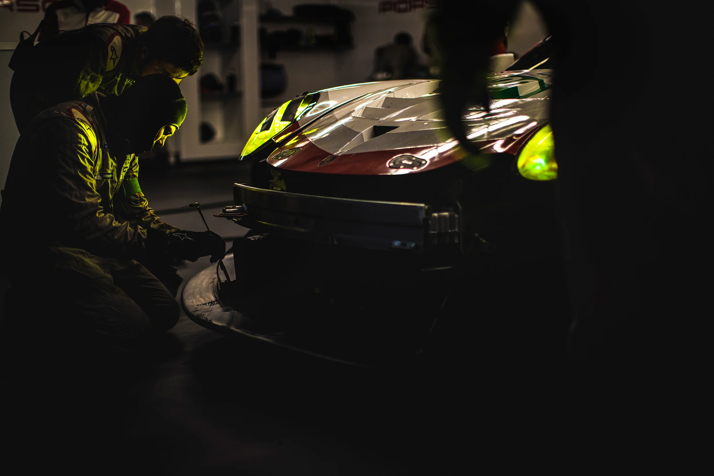 Porsche team members wok on the front splitter of the #92 Porsche 911 RSR