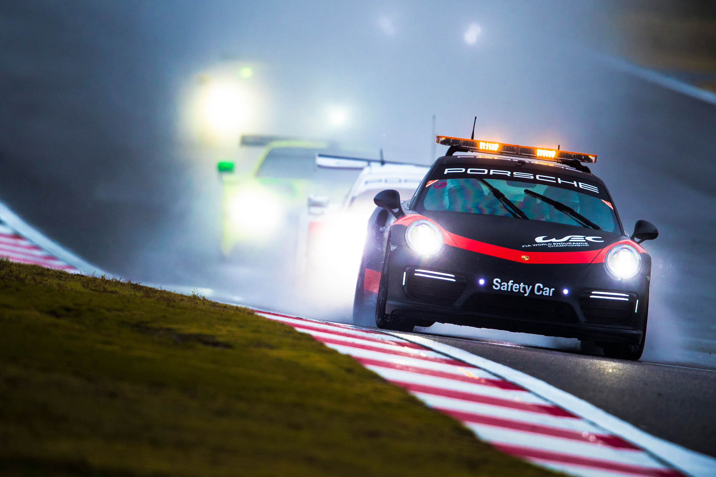 The safety car leads the field