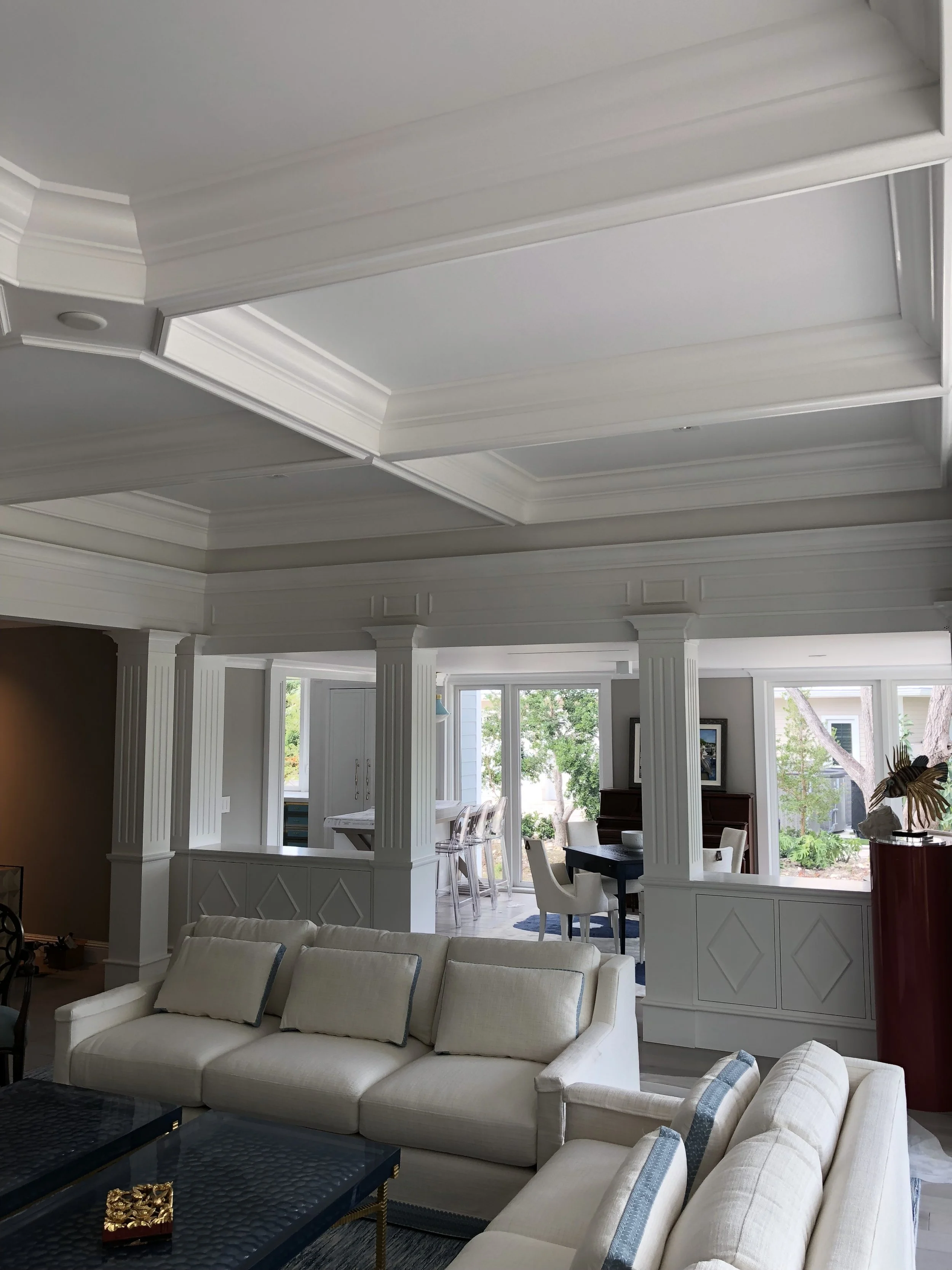 CUSTOM COLUMNS AND CABINETRY COMPLIMENT CEILING BEAMS IN THE LIVING ROOM