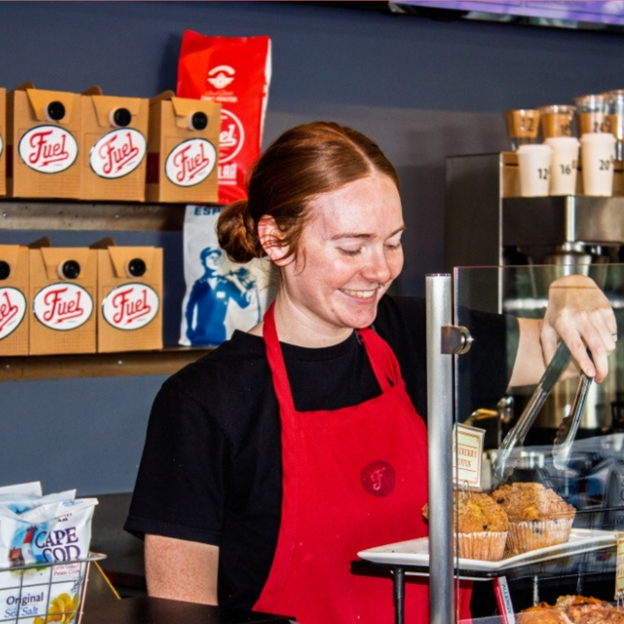 fuel-america-barista-serving-fresh-muffins-cafe-counter.jpg