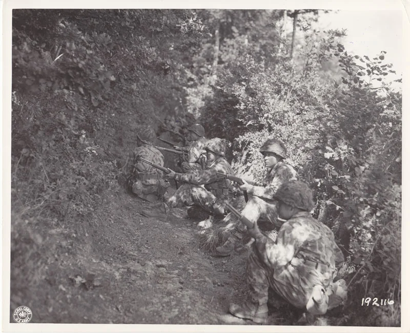 Soldiers await the order to move over hedgerow. Pont Brocard, France, 29 Jul 1944.