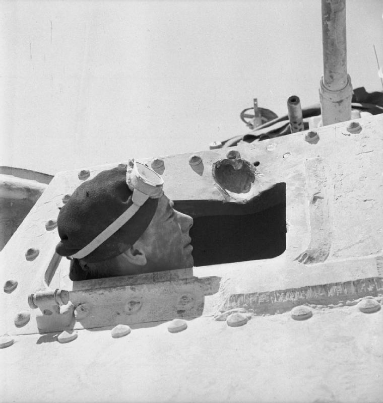 The driver of a Grant tank takes a closer look at a gouge in the armour plate made by a 50mm anti-tank round, Libya, June 1942. IWM photo E 13261