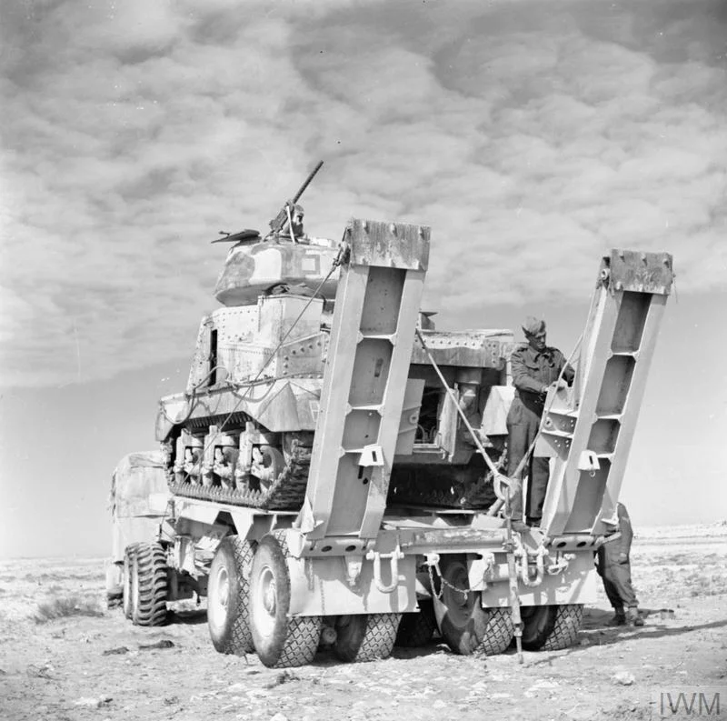Men of the Royal Electrical and Mechanical Engineers secure a Grant tank onto a Scammell tank transporter before taking it to a light repair workshop, 19 Jan 1943. IWM photo E 21407